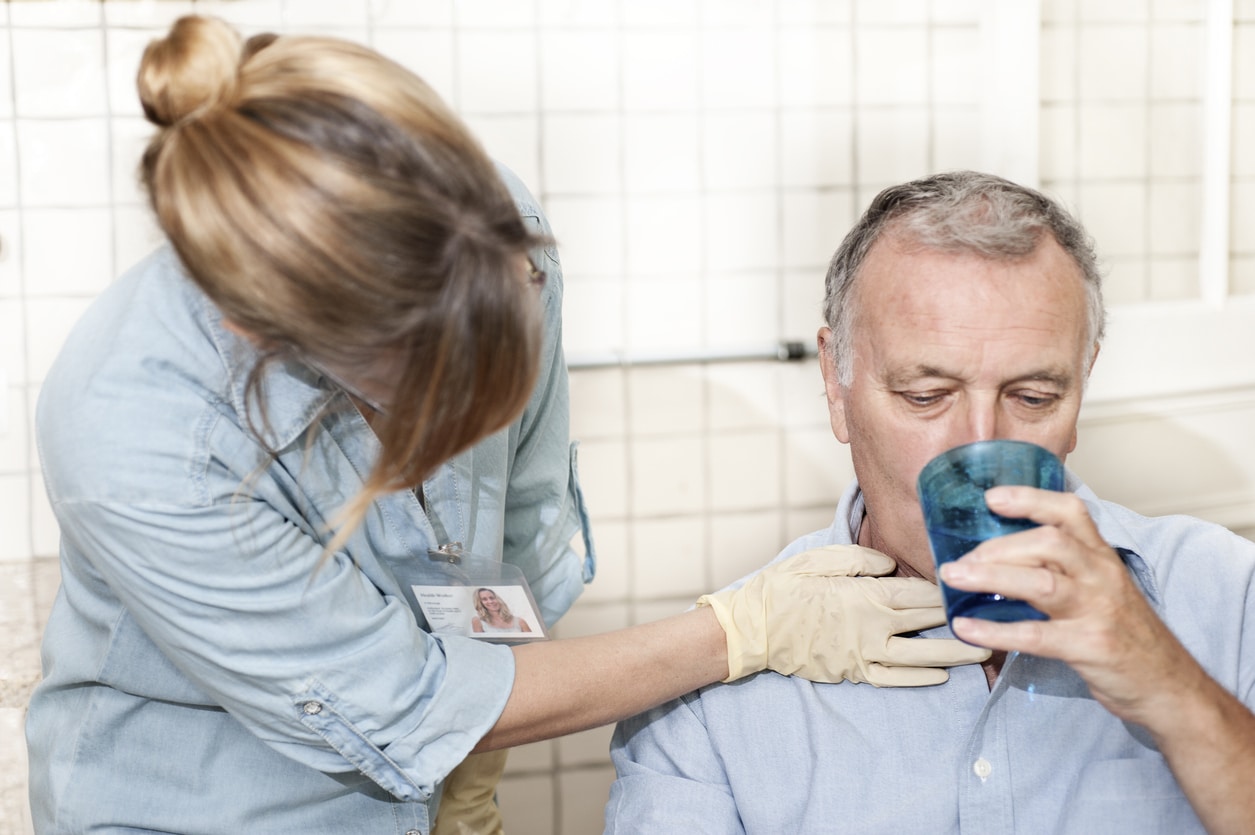Healthcare worker checking man's throat