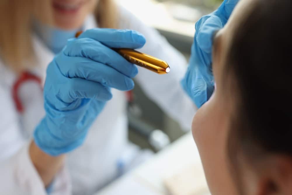 Doctor,Neurologist,Shining,Flashlight,On,Patient,Eyes,In,Clinic,Closeup.